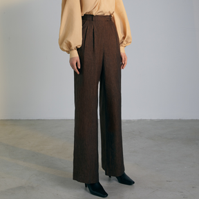 The front of a model wearing brown colored loose Pants