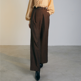 The front of a model wearing brown colored loose Pants